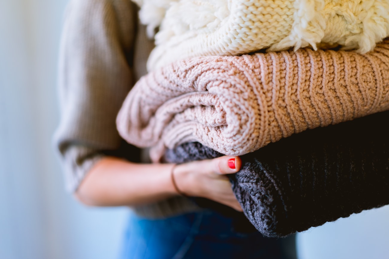 Armful of folded soft knits and throws